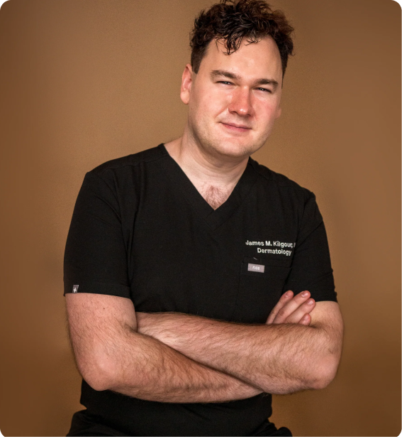 Medical professional in black scrubs standing with arms crossed against a warm brown background