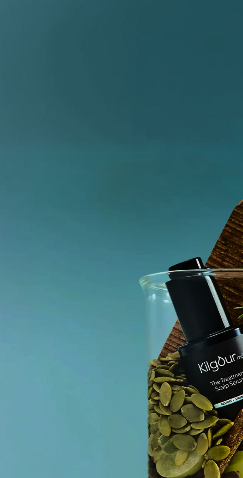 Angled close-up of KilgourMD scalp serum pump in glass jar with pumpkin seeds and wood on teal background