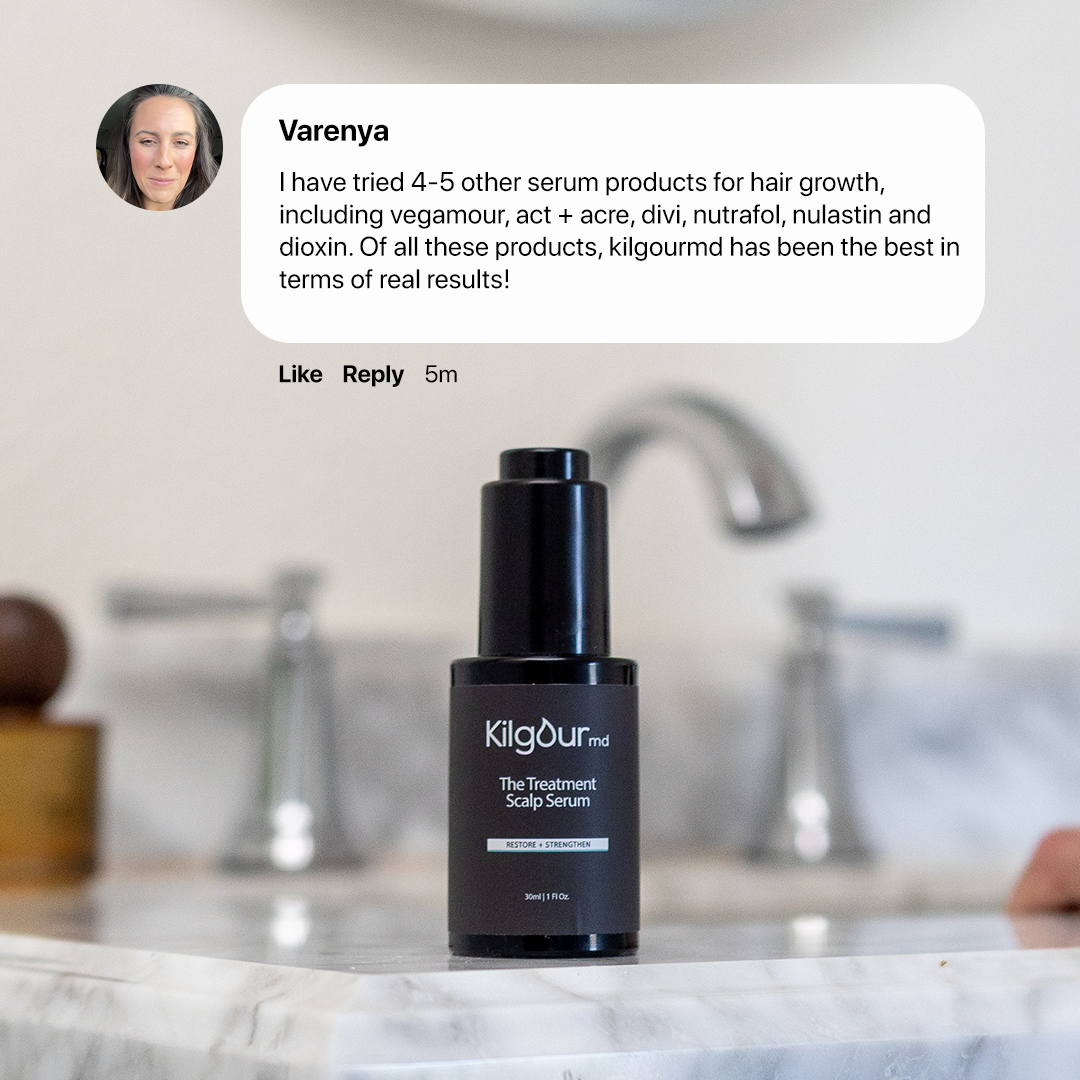 Front view of The Treatment Scalp Serum bottle with matte black pump on a marble sink, blurred faucet, and an overlaid customer review by Varenya